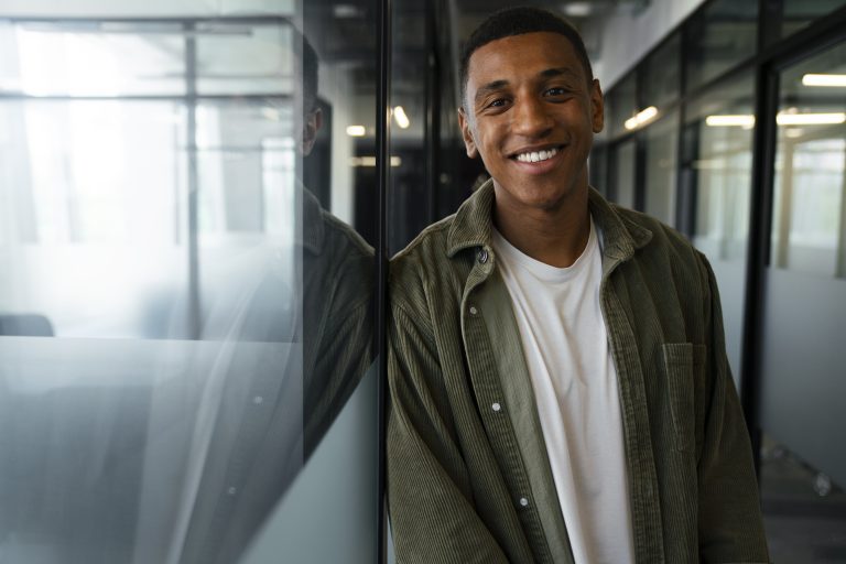 homem-sorridente-durante-seu-tempo-de-trabalho-em-um-trabalho-de-escritorio
