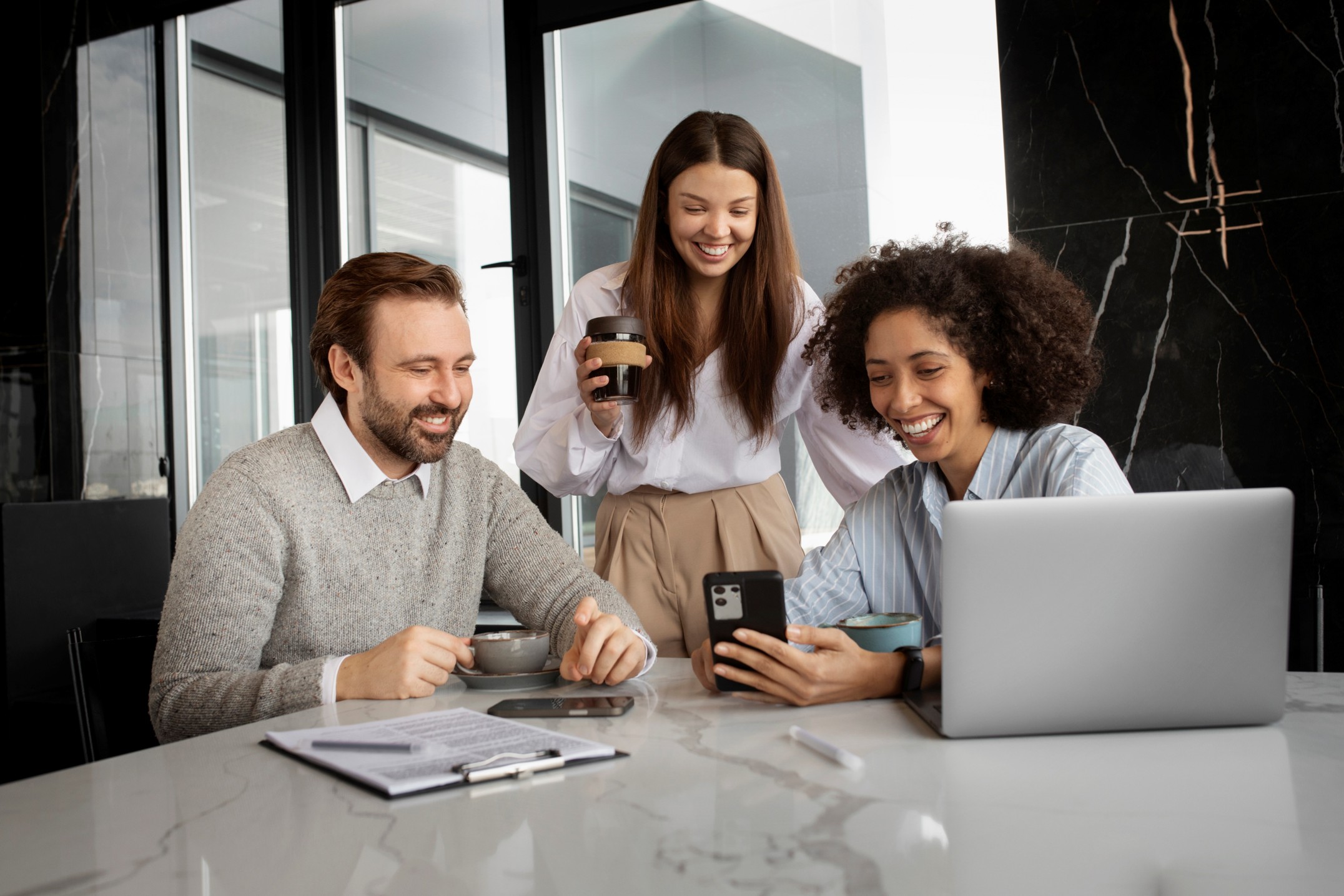 medium-shot-smiley-colleagues-with-smartphone