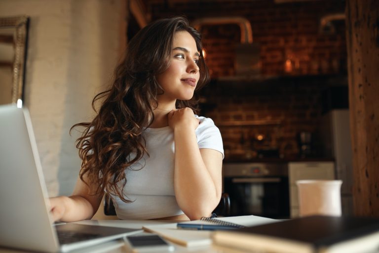 cute-young-female-with-long-wavy-hair-enjoying-sunny-day-using-portable-computer-distant-work-having-dreamy-look-charming-student-girl-studying-online-laptop-home-selective-focus